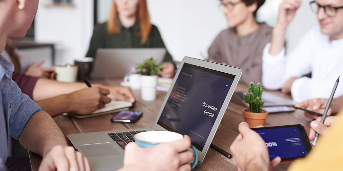 Team meeting, discussion outline on laptop.