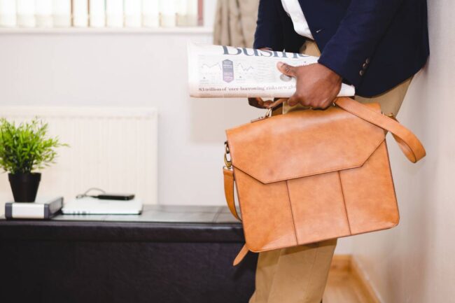 Businessman briefcase newspaper office work.