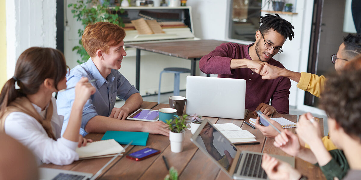 Team giving high fives at meeting. Team giving high fives at meeting.