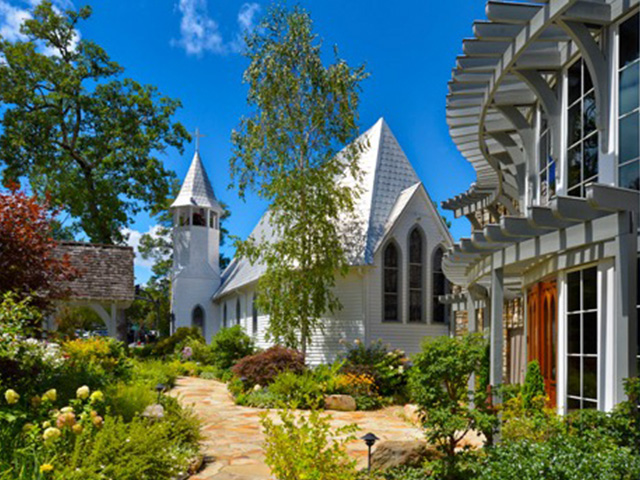 white chapel with a lush garden